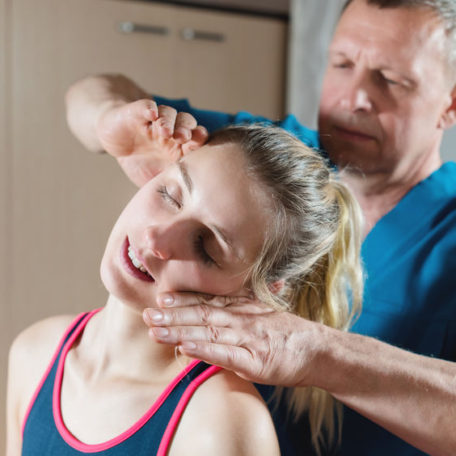 Male manual visceral therapist masseur treats a young female patient. Editing neck and vertebrae